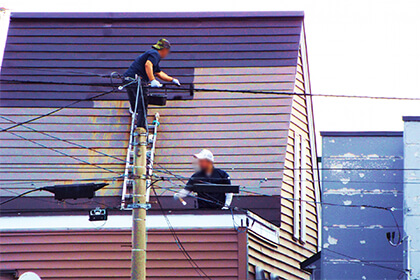 屋根の上で作業をする男性2人