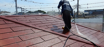 屋根の上で作業をする男性