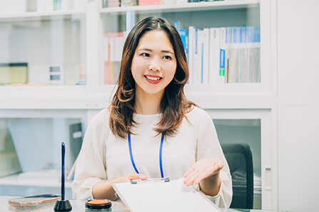 書類をもって説明している女性